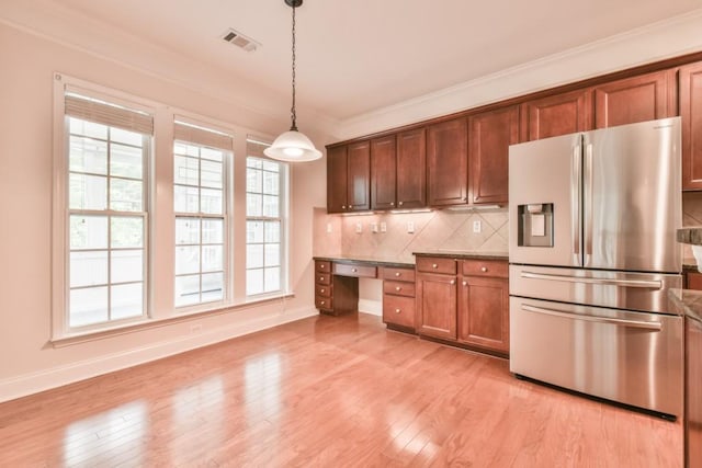 kitchen featuring stainless steel fridge, crown molding, baseboards, decorative backsplash, and pendant lighting