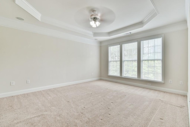 unfurnished room with crown molding, a raised ceiling, ceiling fan, carpet, and baseboards
