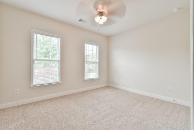 empty room featuring carpet floors, a ceiling fan, and baseboards