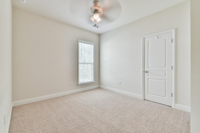 spare room with carpet floors, ceiling fan, and baseboards