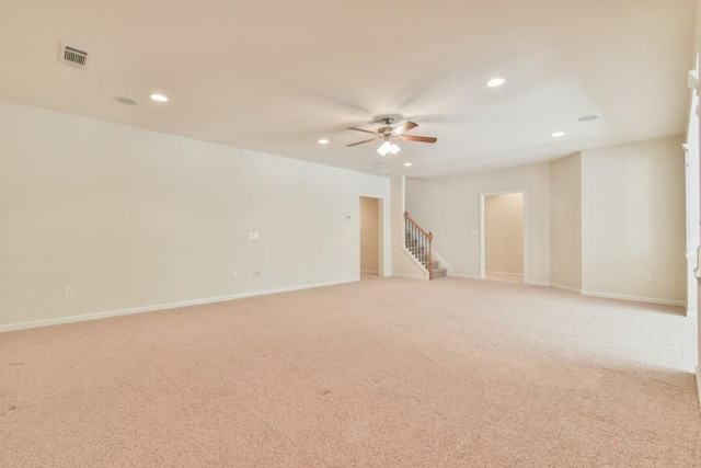 unfurnished room featuring a ceiling fan, recessed lighting, stairs, light carpet, and baseboards