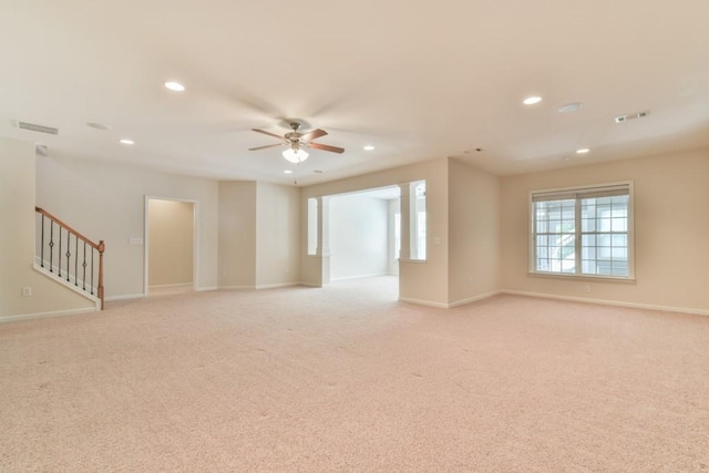 empty room with ceiling fan, recessed lighting, light colored carpet, baseboards, and stairs
