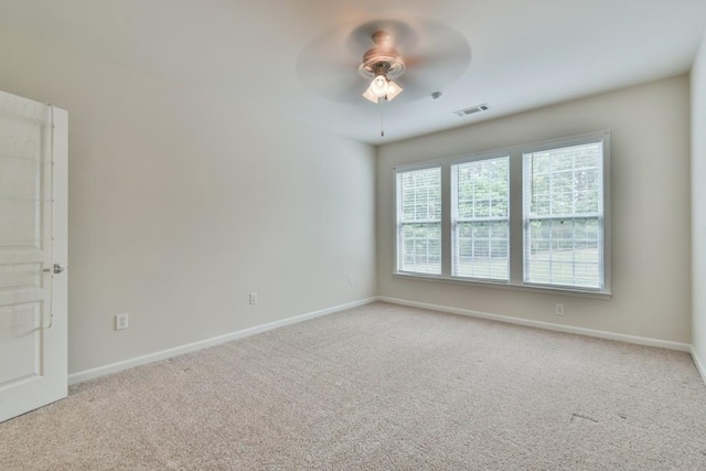 carpeted empty room featuring a ceiling fan and baseboards