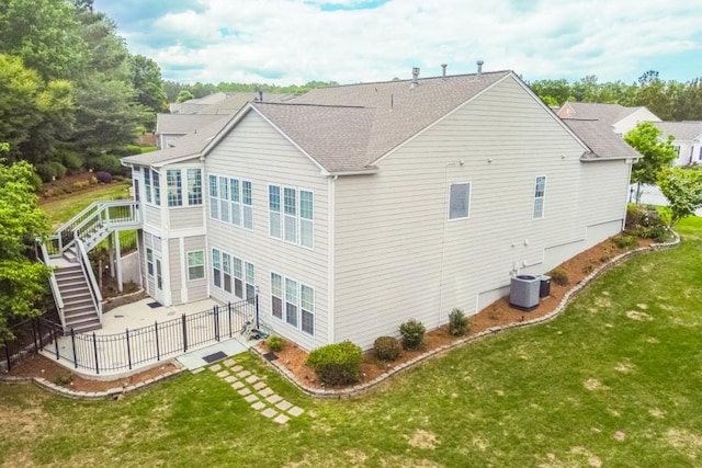 back of property with central AC, a patio, stairway, and a shingled roof
