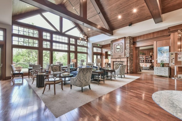 dining area with high vaulted ceiling, plenty of natural light, beam ceiling, a large fireplace, and wooden ceiling
