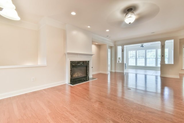 unfurnished living room featuring ornamental molding, wood finished floors, a fireplace, baseboards, and recessed lighting