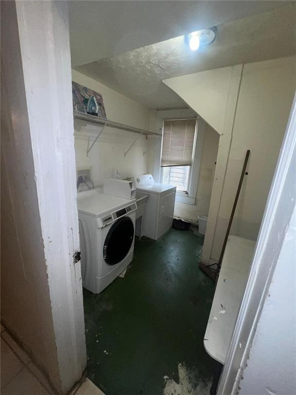 washroom featuring independent washer and dryer and a textured ceiling