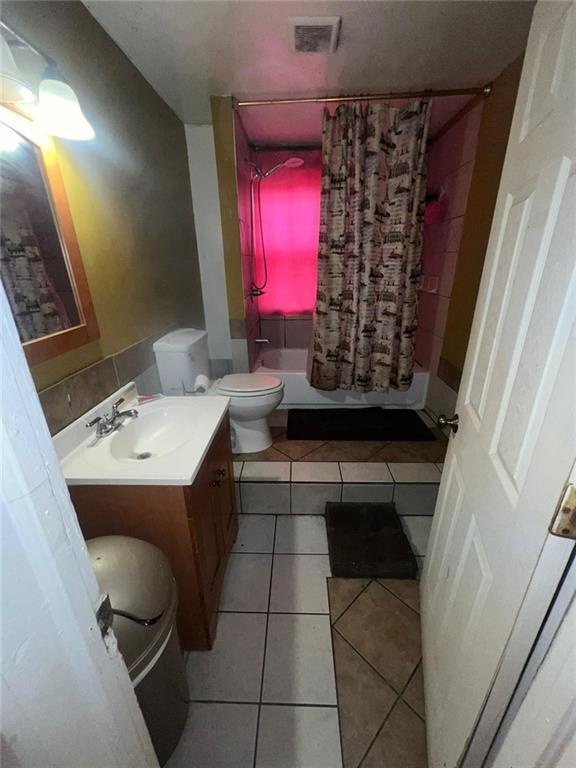 full bathroom featuring vanity, toilet, tile patterned floors, and shower / bath combo with shower curtain