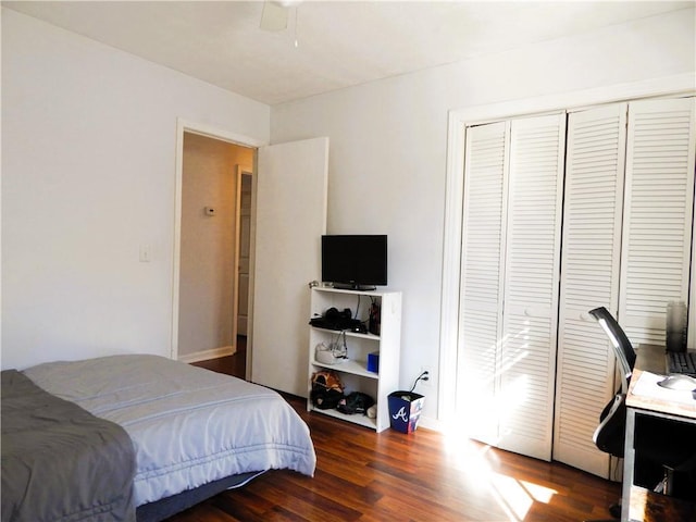 bedroom featuring dark hardwood / wood-style floors, ceiling fan, and a closet