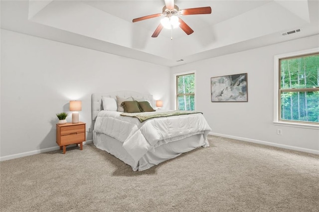 6571 Splitpine Ct, Atlanta, GA 30349 - bedroom featuring a tray ceiling, carpet flooring, baseboards, and ceiling fan