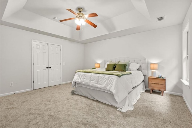 6571 Splitpine Ct, Atlanta, GA 30349 - carpeted bedroom with a tray ceiling, baseboards, and ceiling fan
