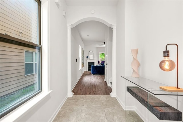 6571 Splitpine Ct, Atlanta, GA 30349 - hallway featuring ornate columns, arched walkways, light tile patterned flooring, and baseboards