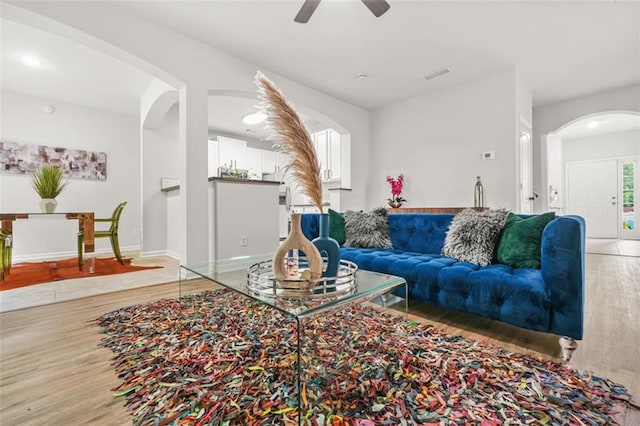 6571 Splitpine Ct, Atlanta, GA 30349 - living room with arched walkways, light wood-style floors, a ceiling fan, and baseboards
