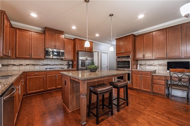 kitchen with crown molding, stainless steel appliances, dark wood-type flooring, and brown cabinets