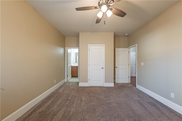 unfurnished bedroom featuring ceiling fan, baseboards, carpet flooring, and ensuite bathroom