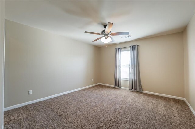 unfurnished room featuring carpet floors, a ceiling fan, visible vents, and baseboards