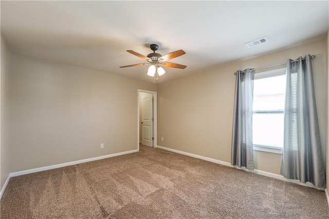 carpeted empty room with baseboards, visible vents, and ceiling fan