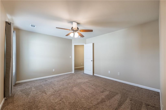 carpeted empty room featuring visible vents, ceiling fan, and baseboards