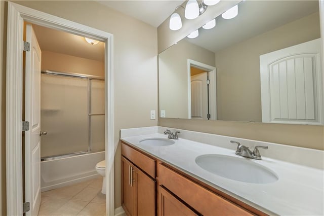 bathroom with tile patterned flooring, a sink, toilet, and double vanity