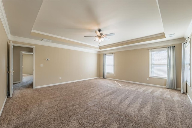 unfurnished room with a raised ceiling, a wealth of natural light, and baseboards