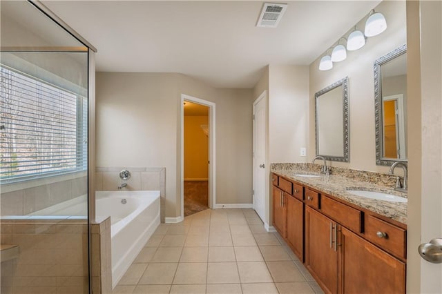 bathroom featuring a garden tub, tile patterned flooring, visible vents, and a sink