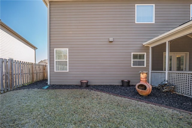 view of property exterior with a yard and fence private yard