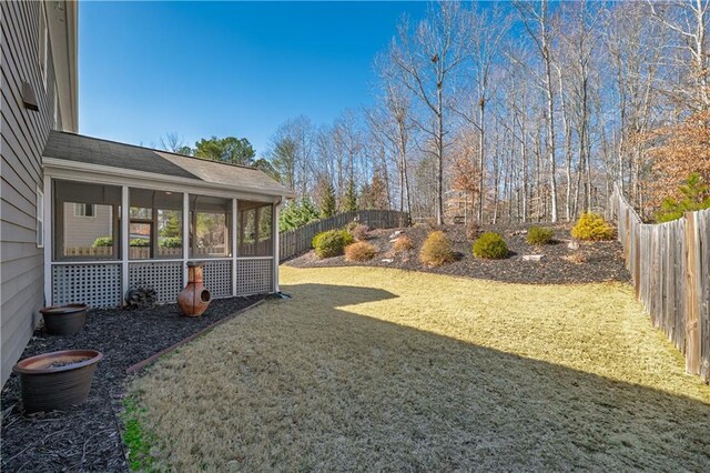 view of yard with a fenced backyard and a sunroom