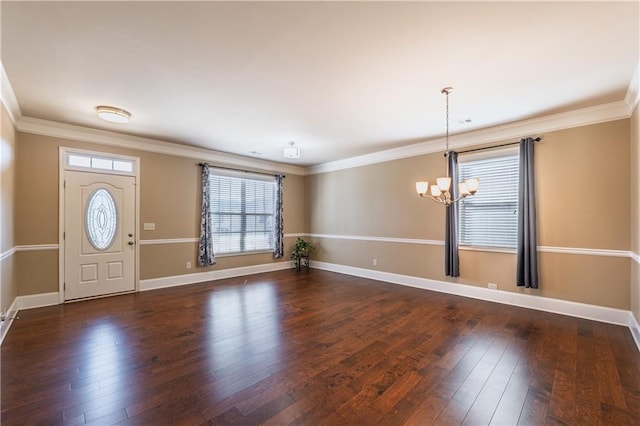 foyer entrance featuring baseboards, a chandelier, dark wood-style flooring, and ornamental molding