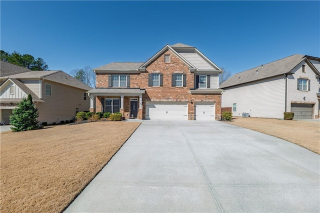 view of front of house with an attached garage, driveway, and brick siding