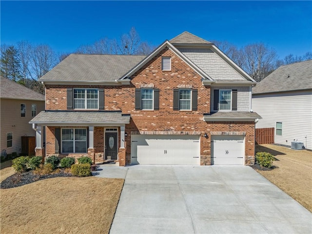 craftsman inspired home with a garage, concrete driveway, central AC, and brick siding