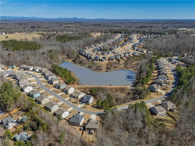 aerial view with a residential view, a water view, and a view of trees