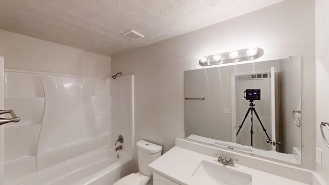 full bathroom featuring toilet,  shower combination, vanity, and a textured ceiling