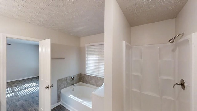 full bath featuring a textured ceiling, a shower, a garden tub, and wood finished floors