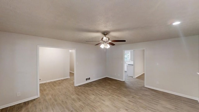 empty room with wood finished floors, a ceiling fan, baseboards, and recessed lighting