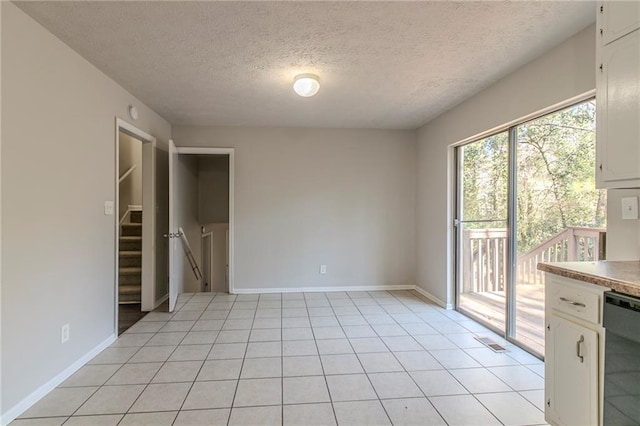 interior space featuring light tile patterned floors and a textured ceiling