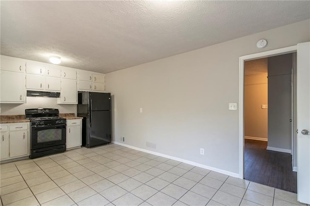 kitchen with white cabinetry, black appliances, a textured ceiling, and light tile patterned flooring