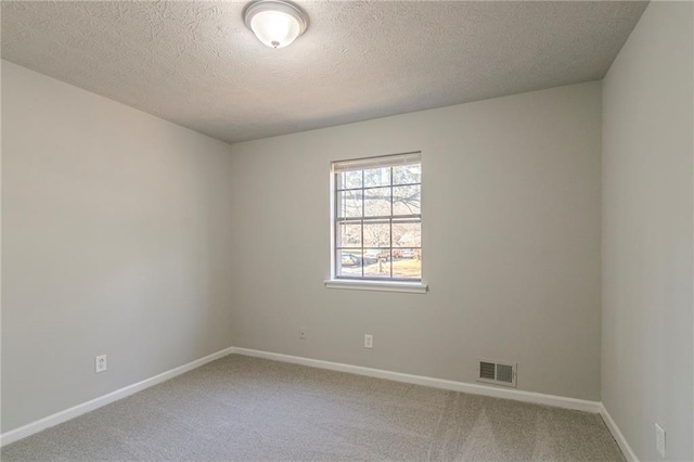 empty room featuring carpet flooring and a textured ceiling