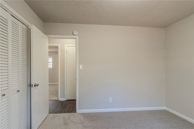 carpeted empty room with a textured ceiling