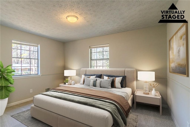 carpeted bedroom with multiple windows and a textured ceiling