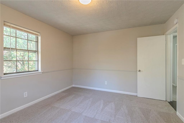 carpeted spare room featuring a textured ceiling