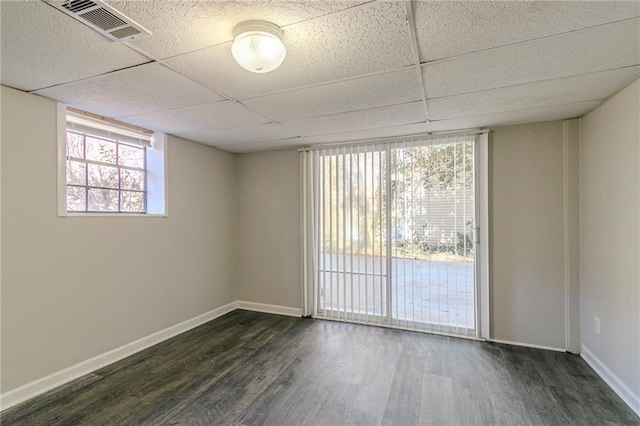 unfurnished room featuring dark hardwood / wood-style flooring and a paneled ceiling