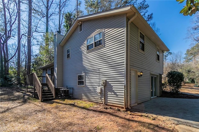 view of side of property featuring a wooden deck and a garage