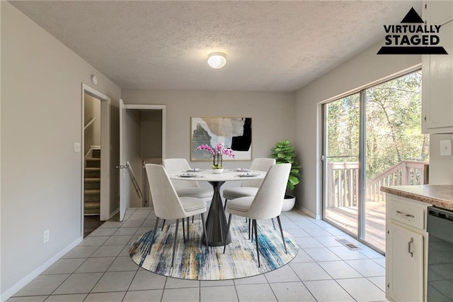 dining area with light tile patterned floors and a textured ceiling