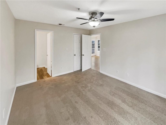 unfurnished bedroom with ceiling fan and carpet floors