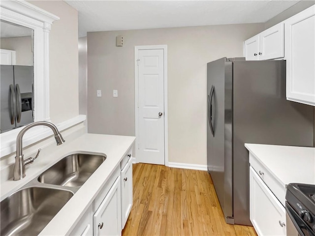 kitchen with sink, stainless steel refrigerator with ice dispenser, stainless steel fridge, white cabinets, and light wood-type flooring