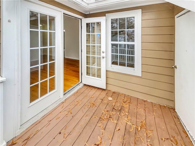 exterior space featuring ornamental molding, wooden walls, and light hardwood / wood-style flooring