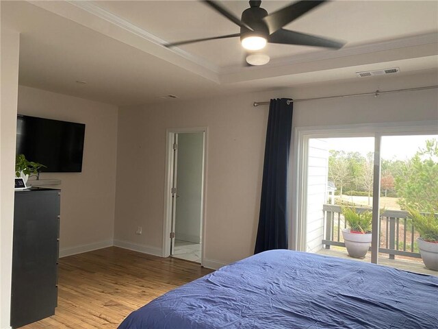 bedroom featuring access to outside, a raised ceiling, ceiling fan, and wood-type flooring