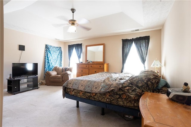 carpeted bedroom featuring multiple windows and a ceiling fan