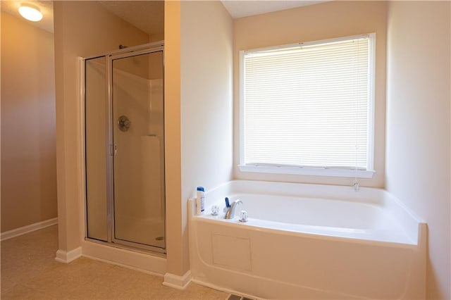full bath with a bath, a stall shower, and baseboards