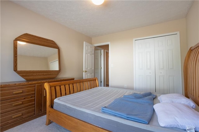 bedroom featuring carpet flooring, a closet, and a textured ceiling